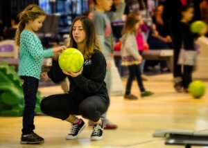 mom showing daughter how to bowl