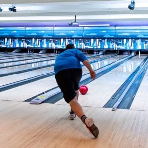 Back view of man releasing a bowling ball down a lane at Rab’s Country Lanes