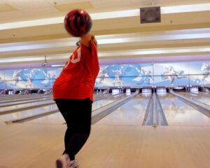 Woman about to release bowling ball down an alley at Rab's Country Lanes