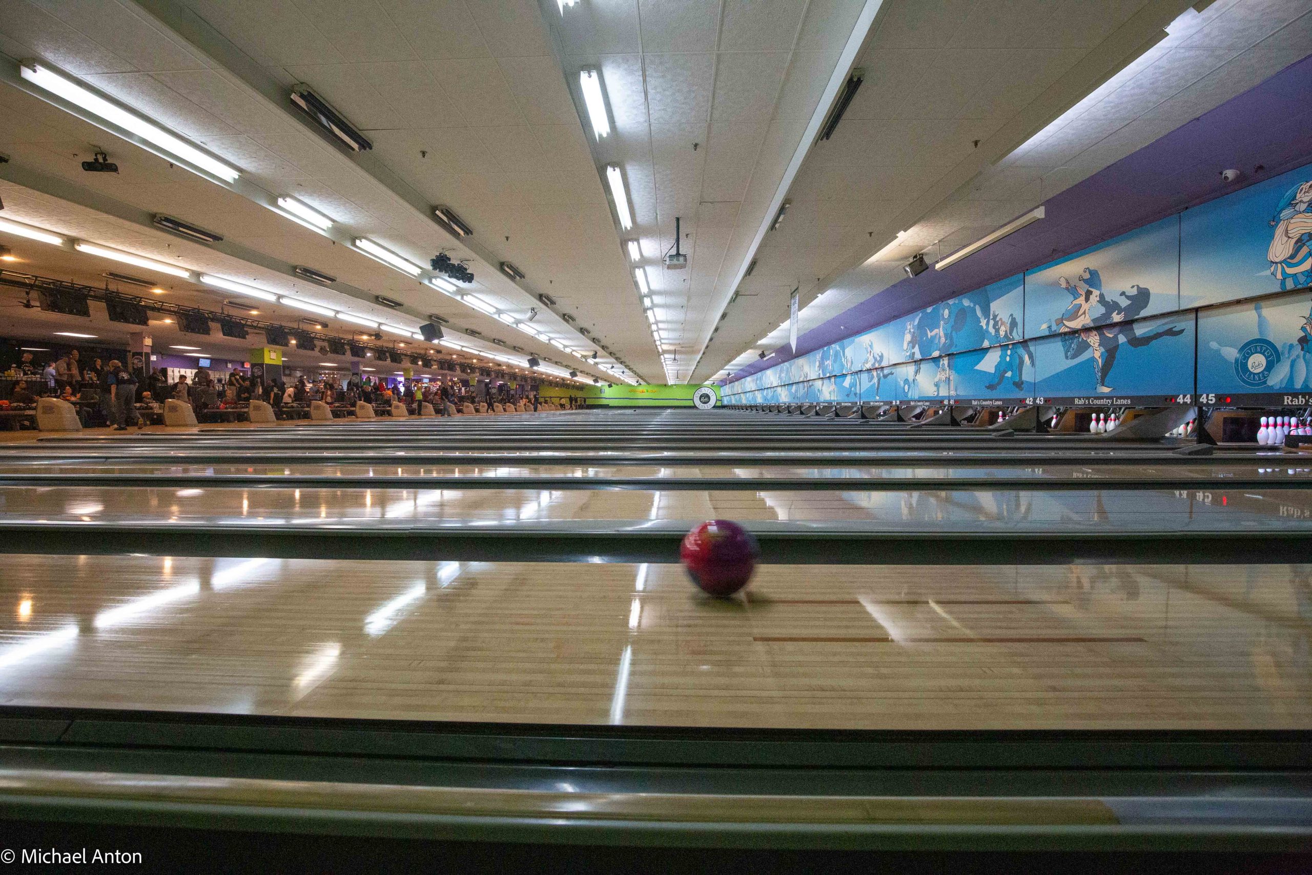 Photo of a bowling ball in motion down a lane