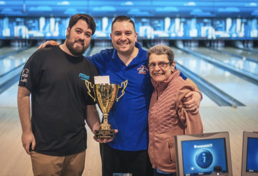 2022 Staten Island Singles Classic winner Mickey Endress stands between tournament director Michael Ruffe, left, and his mom, Peggy Lee Endress. (Photo courtesy of Mike Giovinazzo)