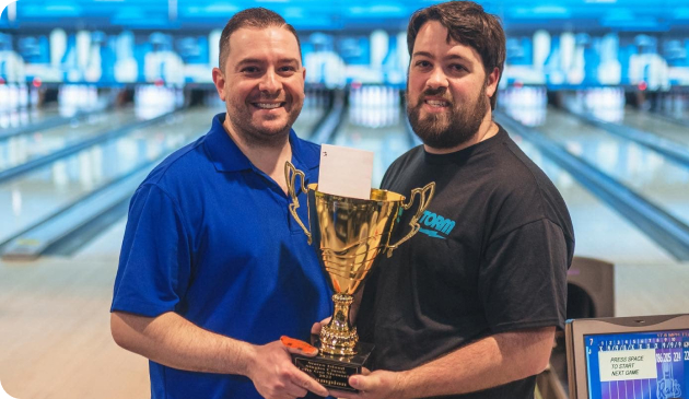 Two gentlemen holding a trophy together